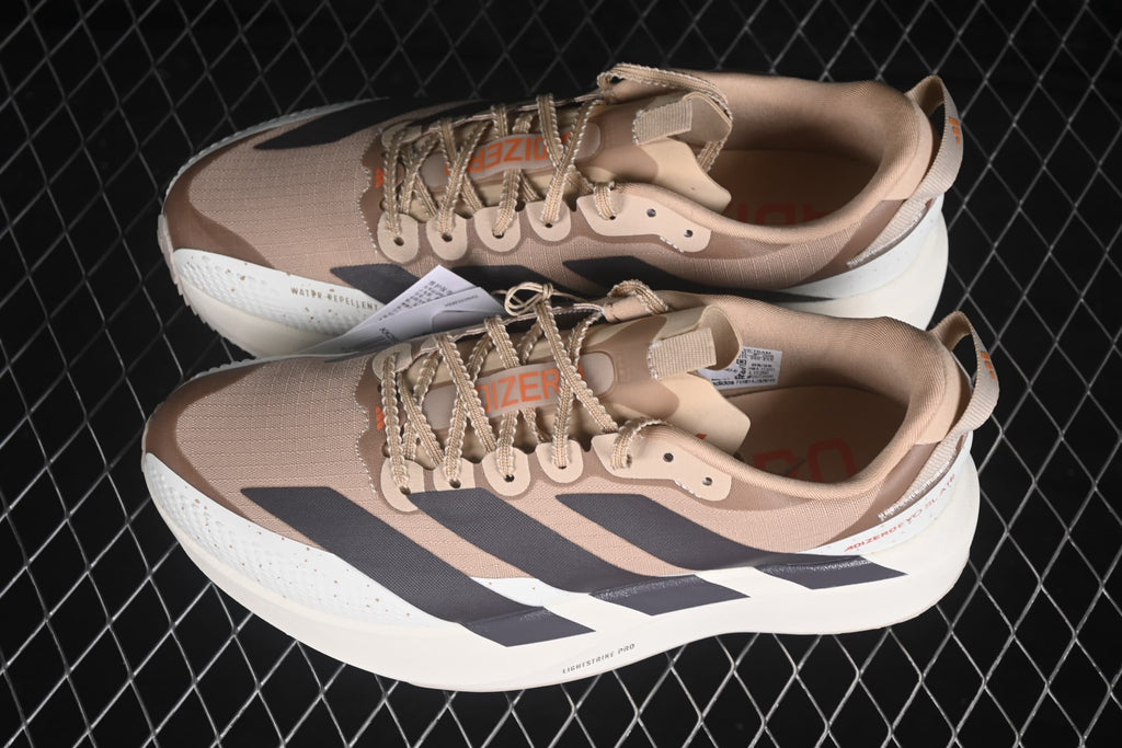 Angled overhead view of the pair showing the beige and cream colorway, lace details and contrasting stripe panels.