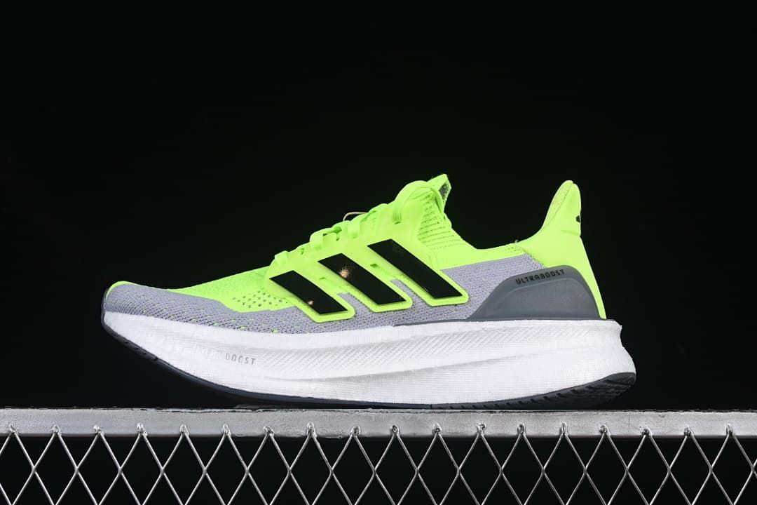 Side view of lime green and gray Ultraboost running shoe with black stripes and white midsole
