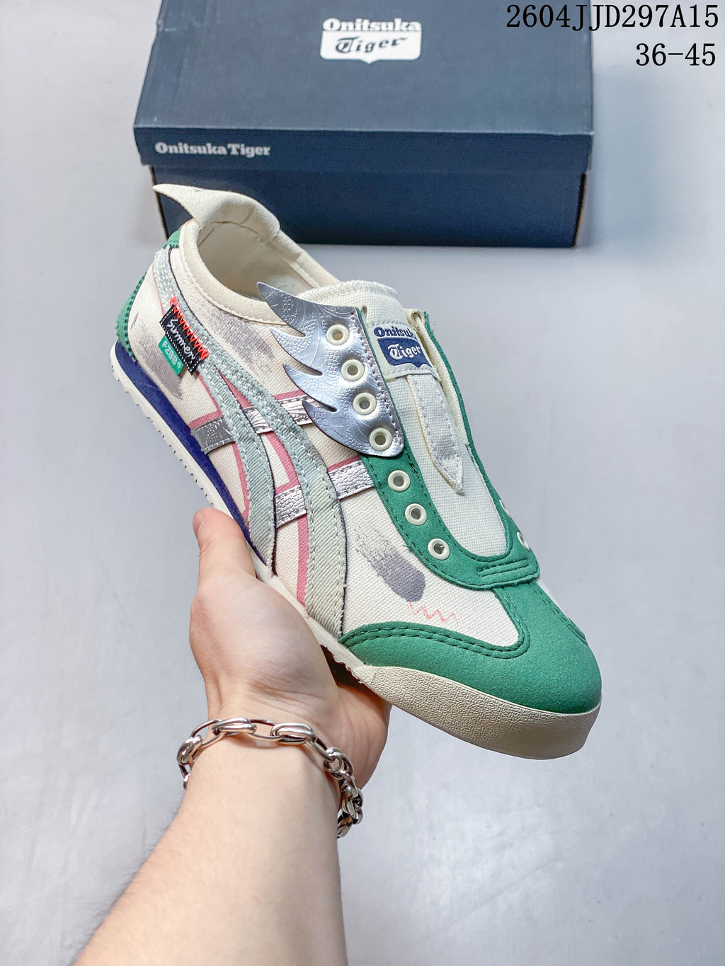 Angled view of the sneaker showing its off-white, green, silver, and pink design