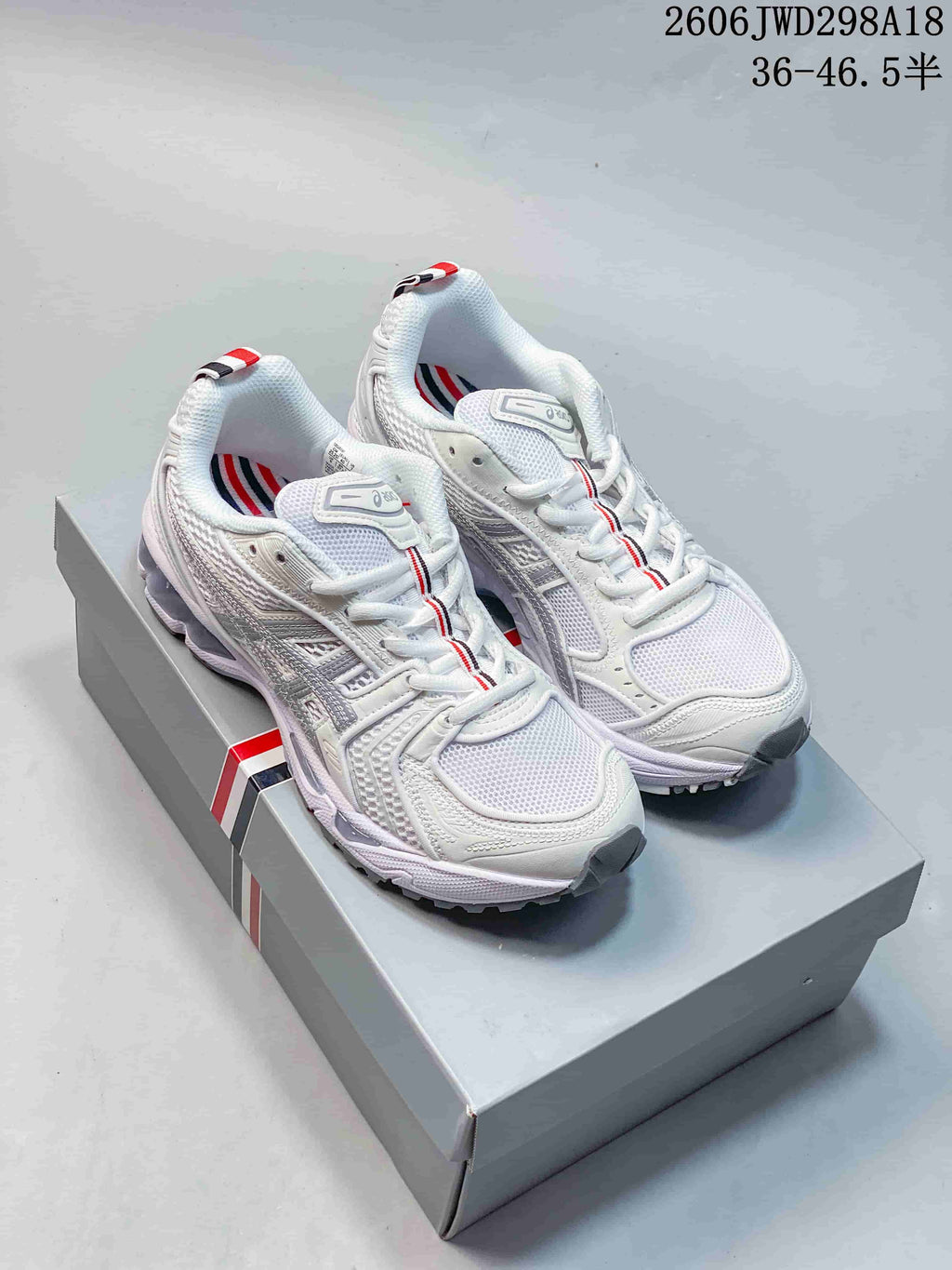 Pair of white sneakers with layered panels and red, white, and dark heel-tab accents.