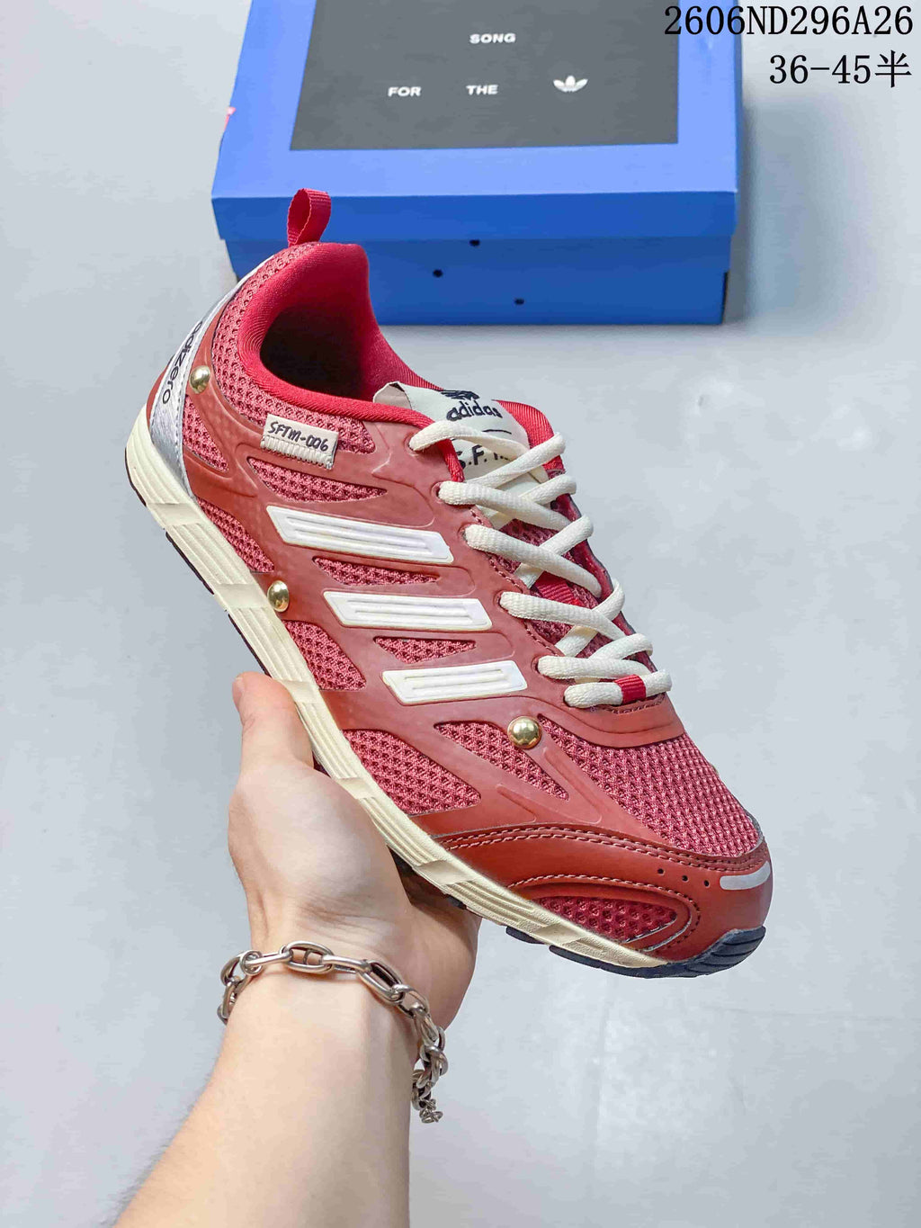 Angled side view of a red Adidas Originals PR SFTM sneaker with cream laces