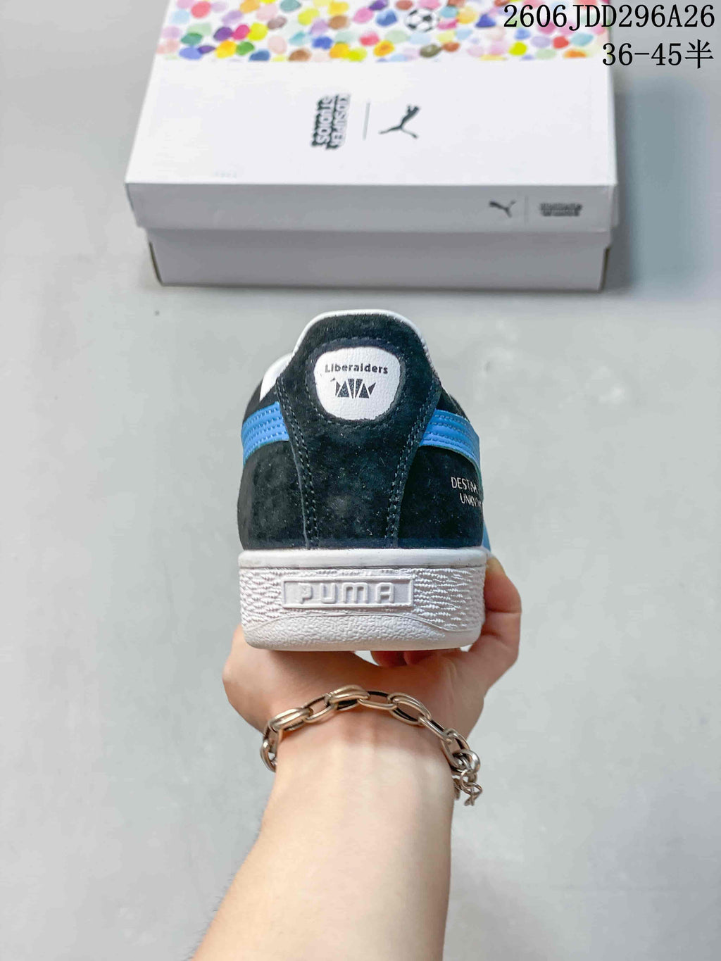 Rear view of a dark PUMA sneaker with blue detailing and a white sole.