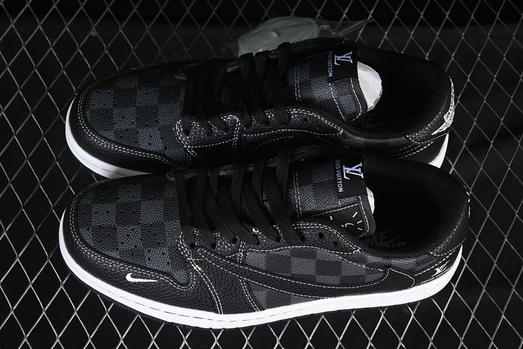 Overhead view of a pair of black low-top sneakers showing check-pattern toe and side panels, black laces, contrast stitching, and white midsoles.