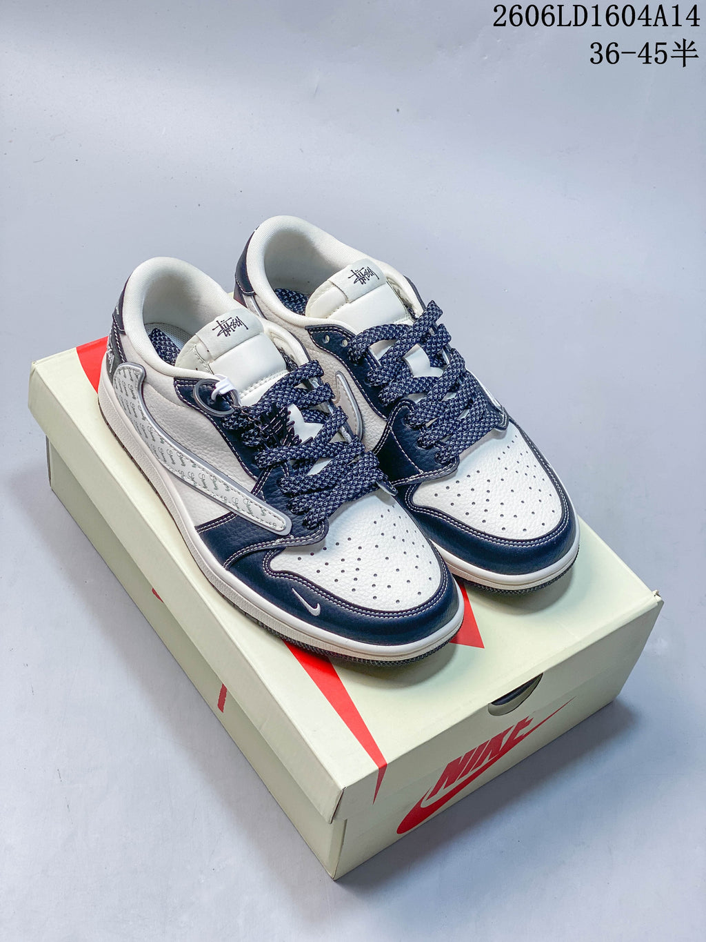 Pair of white and navy low-top sneakers with patterned side panels and contrasting laces