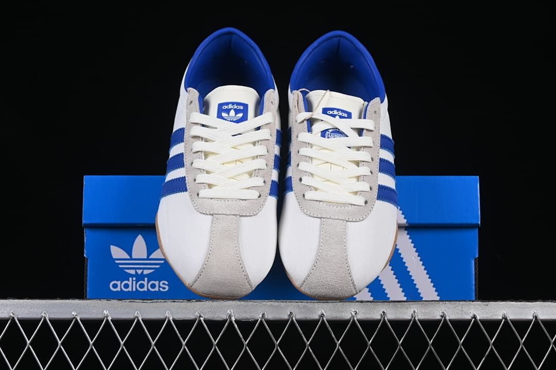 Front view of the sneakers displayed on a blue shoe box