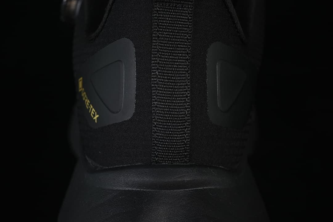 Rear view of the black shoe showing the heel pull tab and GORE-TEX-marked panels.