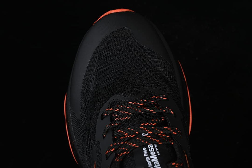 Top view of the shoe's black toe and orange-accented laces.