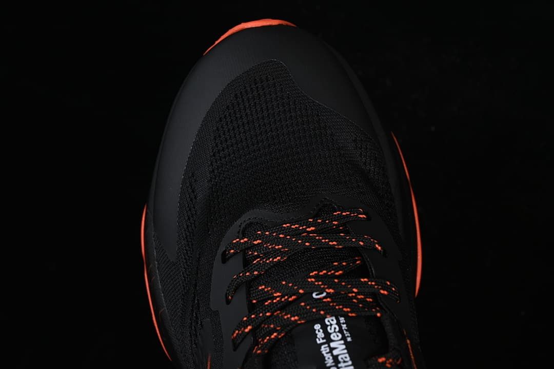 Top view of the shoe's black toe and orange-accented laces.