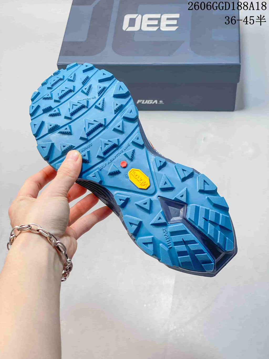 Close-up of the blue trail shoe outsole showing its prominent tread lugs