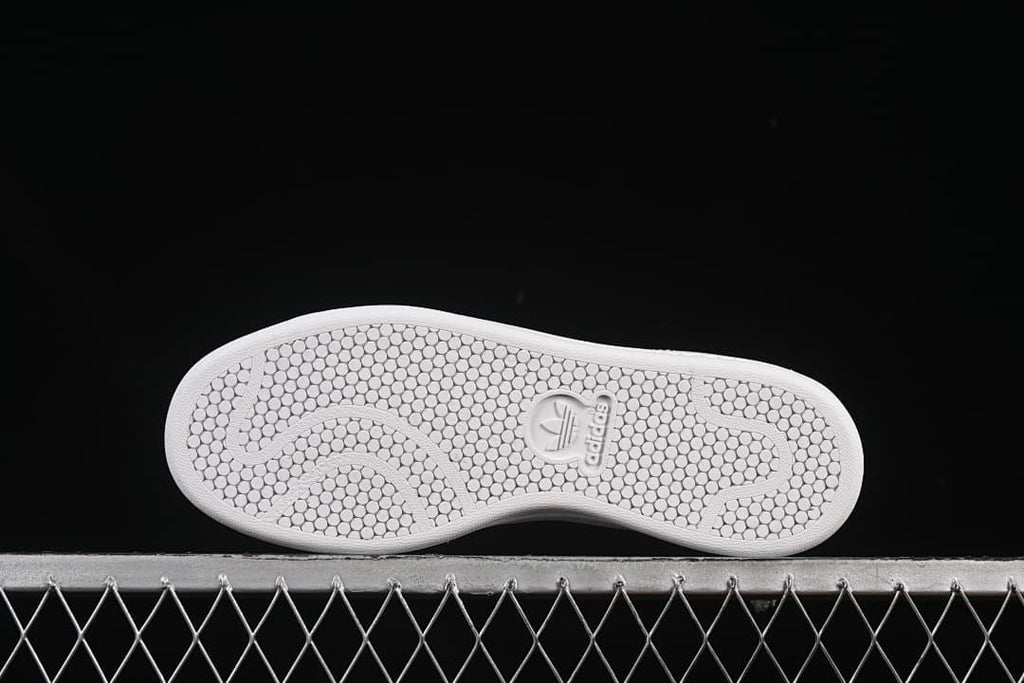 Underside showing the white outsole’s circular tread pattern.
