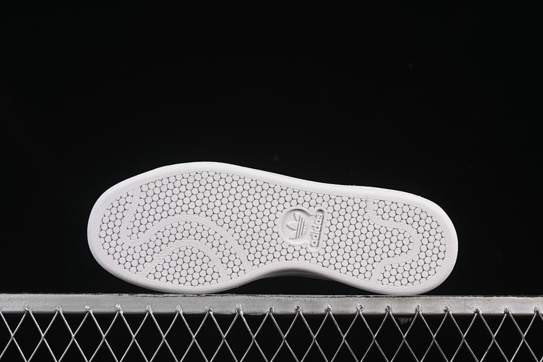 Underside showing the white outsole’s circular tread pattern.
