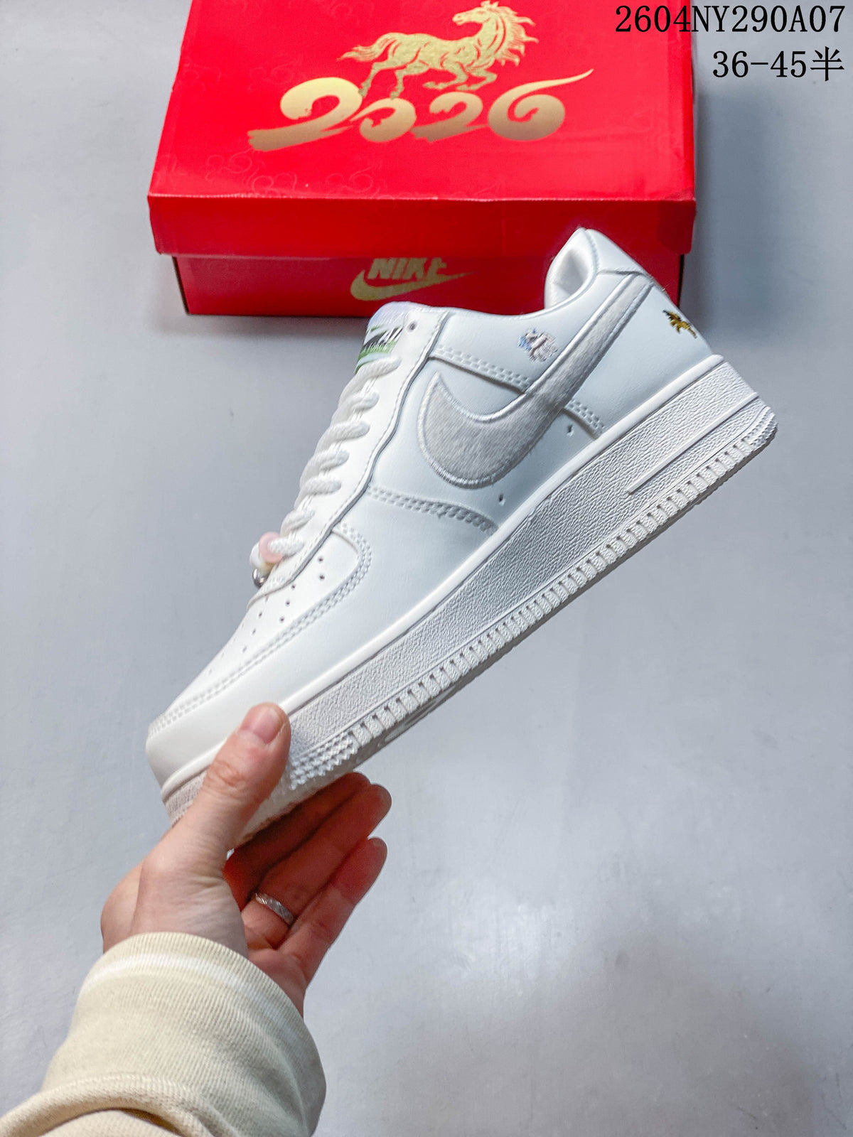 Side view of a white low-top sneaker with a silver side panel and embroidered horse details.