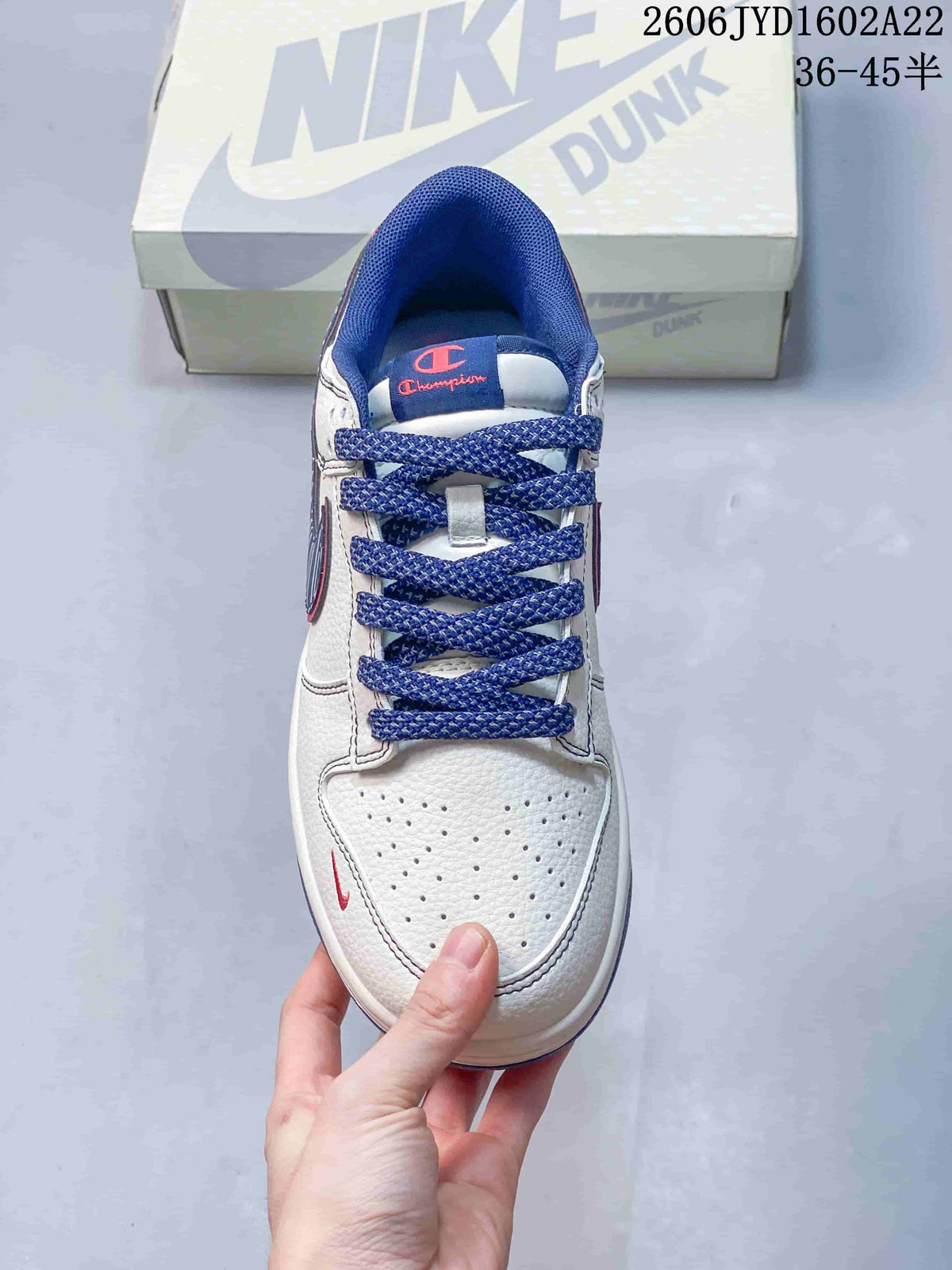 Top view of a white sneaker with blue laces and perforated toe