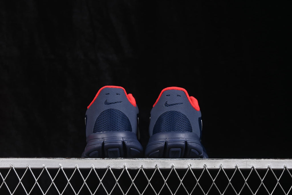 Rear view showing the navy heel panels, red collar accents, and segmented outsole.
