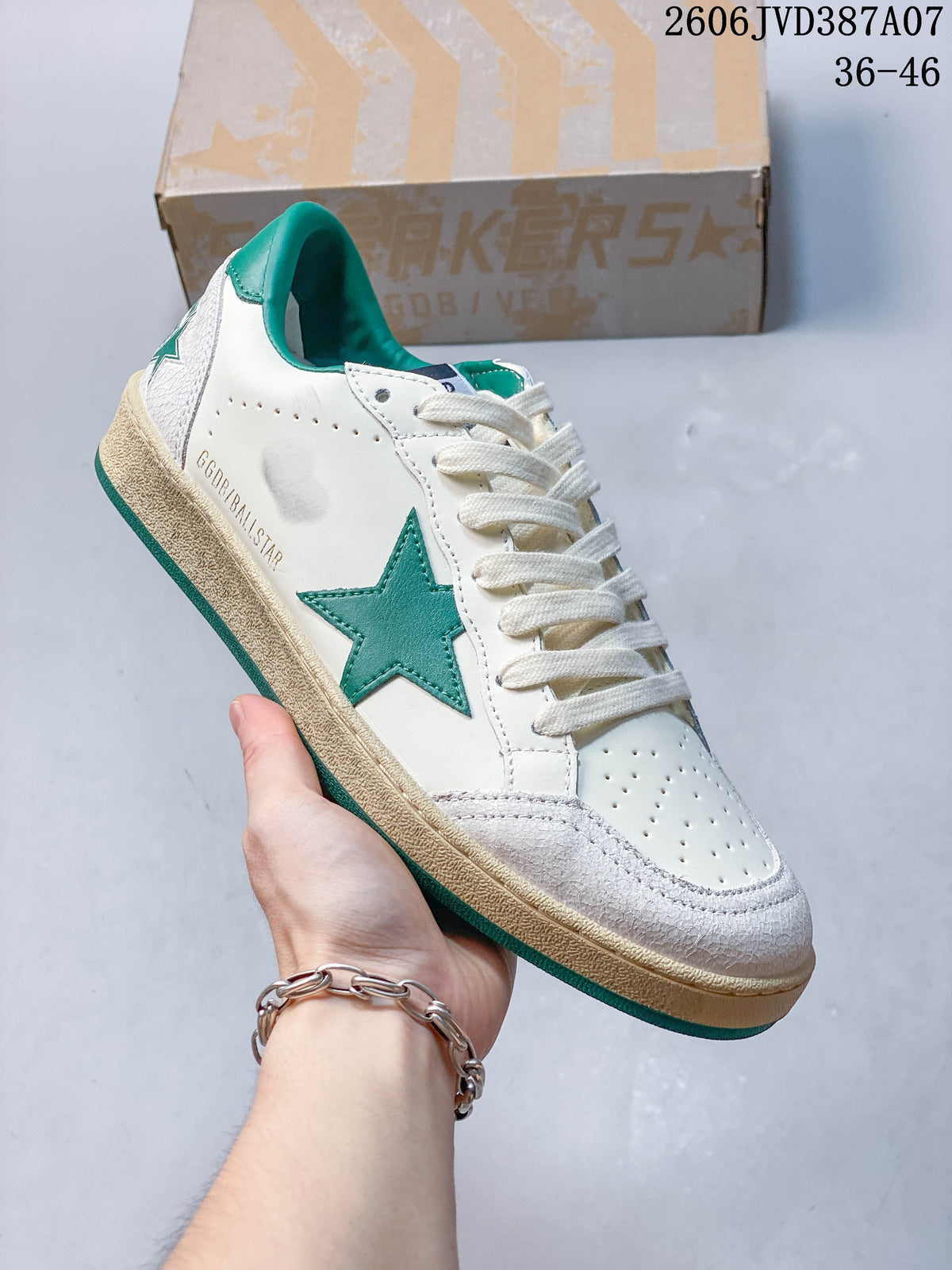 Side view of the white low-top sneaker with green star detail and distressed-look sole.