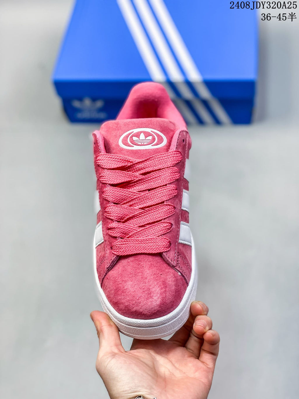 Front view of a pink lace-up sneaker with wide laces and white side stripes.