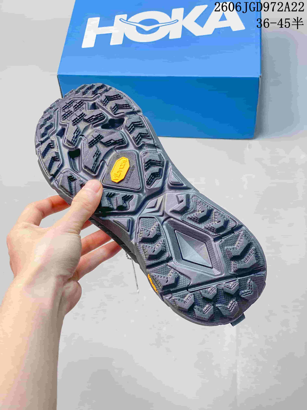 View of the lugged outsole on a charcoal-gray HOKA trail shoe