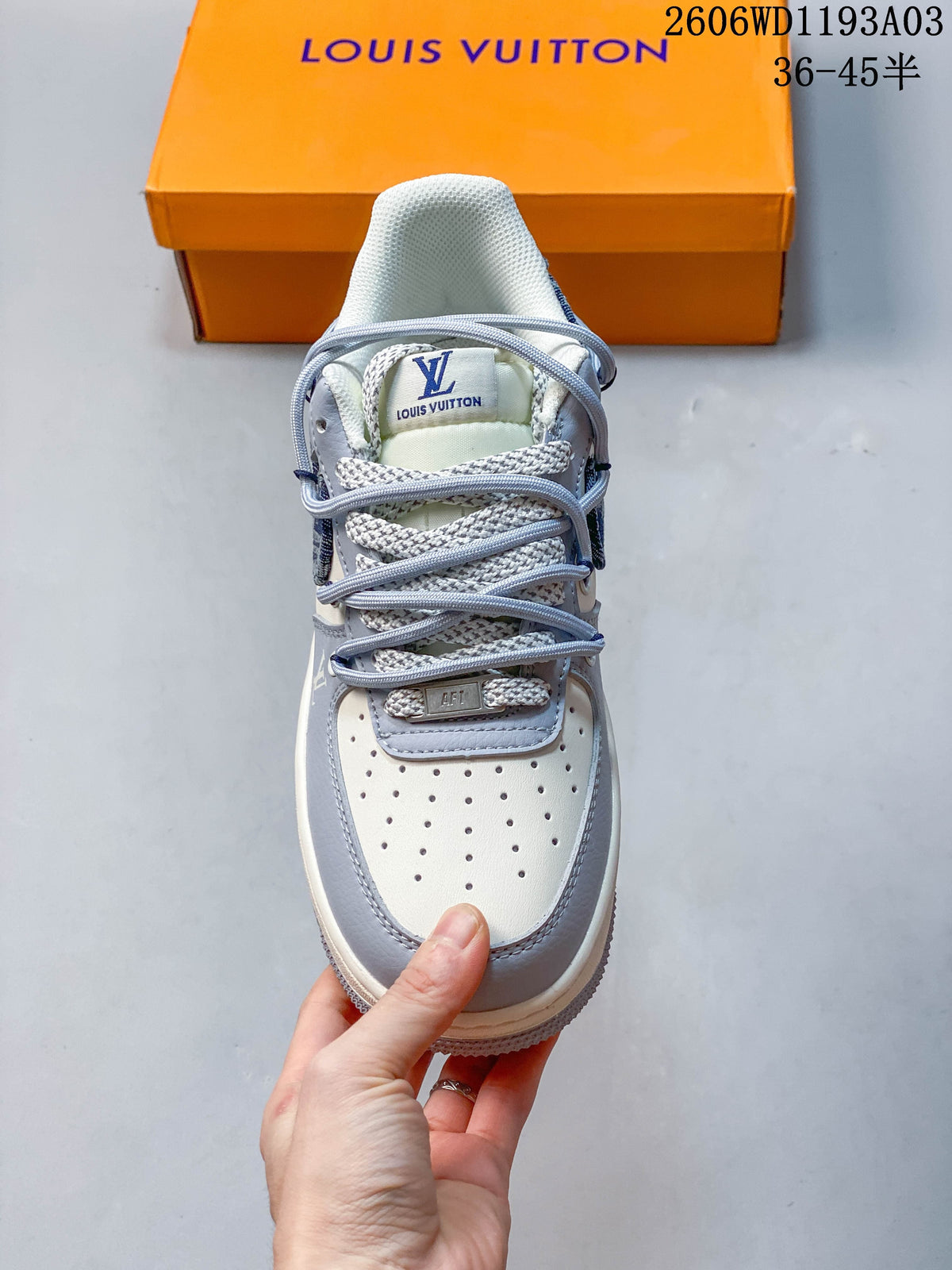 Top view of the sneaker showing a perforated white toe, layered laces, and pale gray trim.