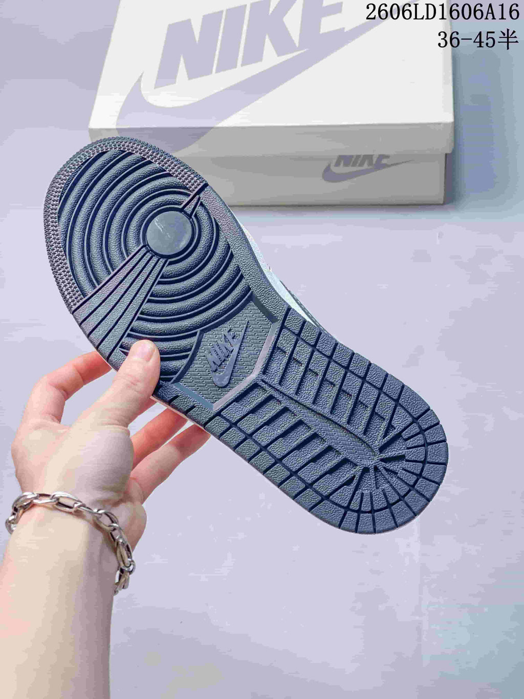 Close-up of the navy outsole; image also displays a size range.