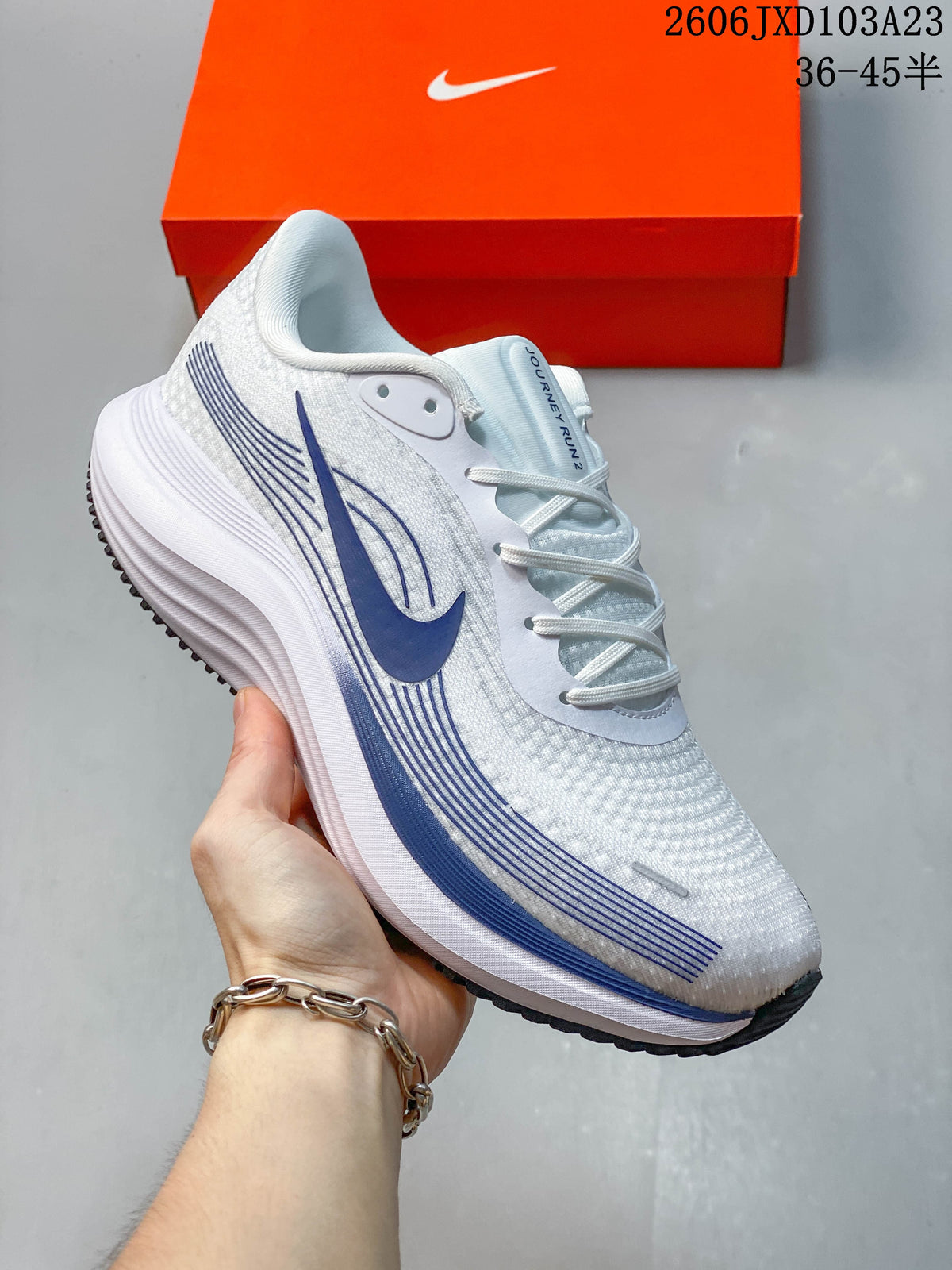 Side view of a white Nike running shoe with blue accents and a ridged midsole.