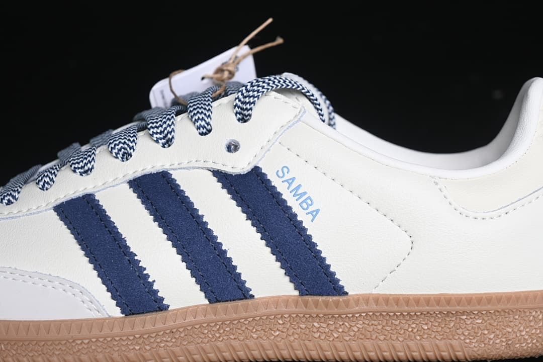 Close-up of navy side stripes and patterned laces on the white upper.