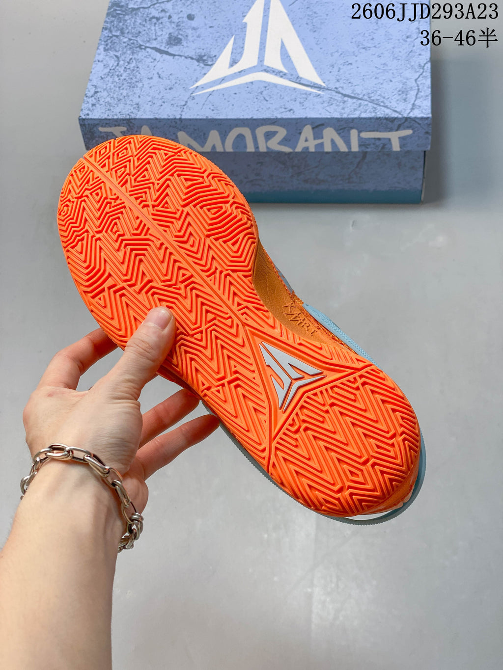 Close-up of the orange shoe's patterned rubber outsole.