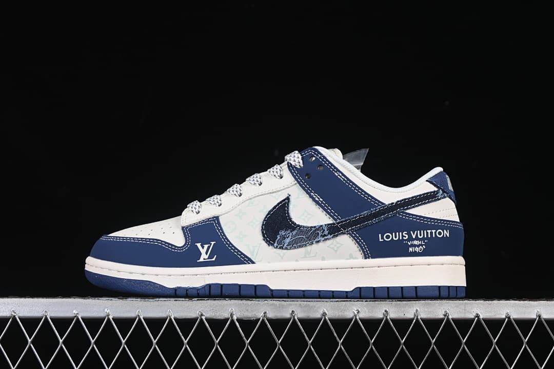 Side view of a white and navy low-top sneaker with a patterned denim-look swoosh and monogram-style panels.