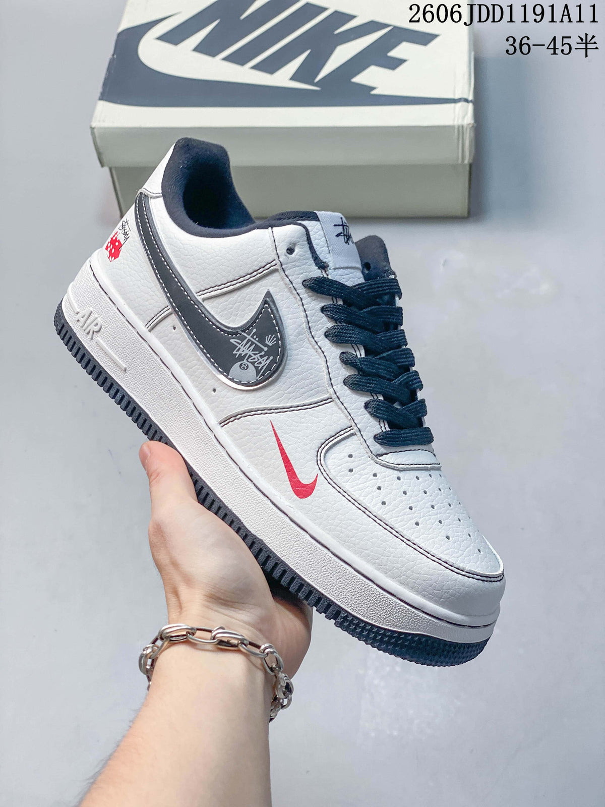Angled side view of the white low-top sneaker with navy and red accents