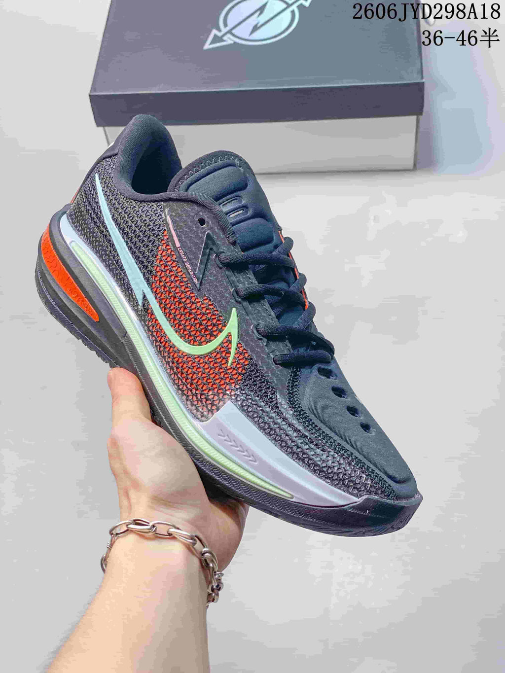 Dark gray Nike Air Zoom GT Cut low-top shoe with a pale green accent and orange details.