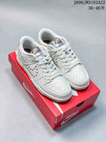 White Nike Dunk Low sneakers with silver-tone side studs on a red shoe box