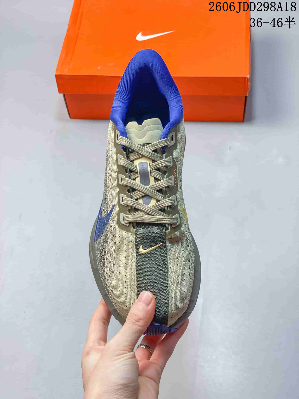 Top view of a lace-up running shoe with gray-green panels and blue collar lining