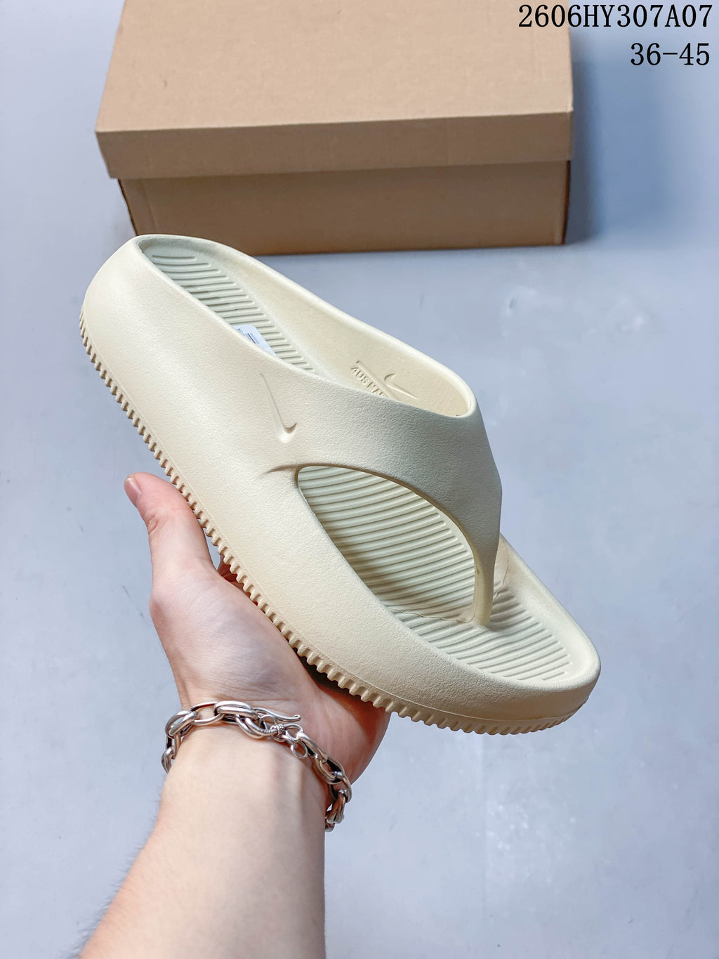 Angled view of the pale cream Nike Calm Slide sandal