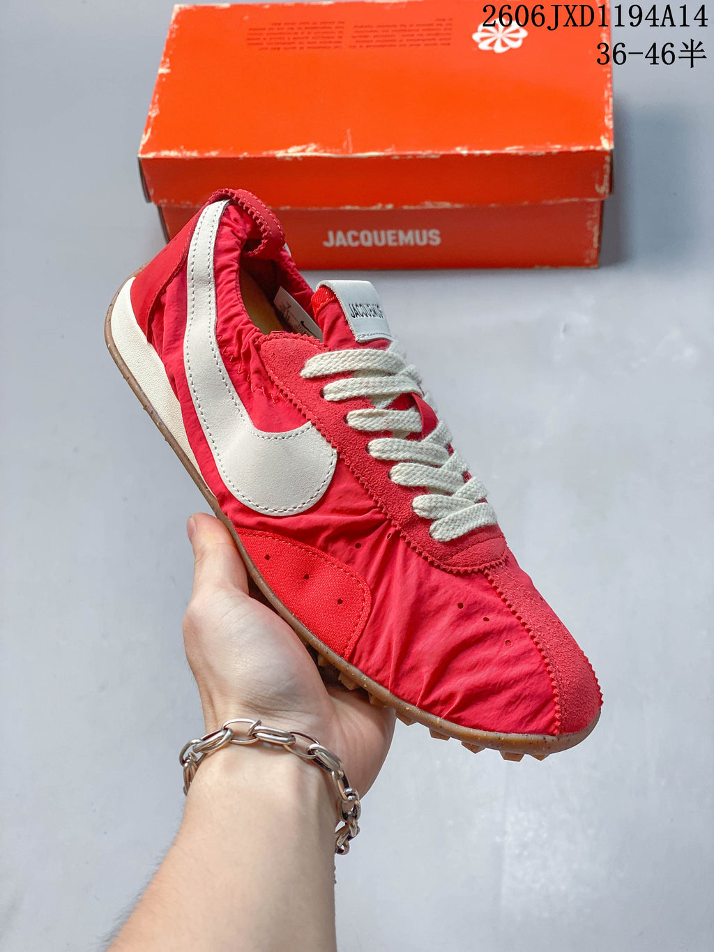 Angled side view of the red sneaker with off-white swoosh and gum outsole