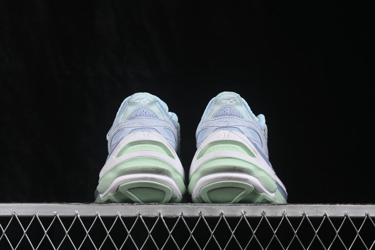Rear view of the pair showing the padded heels and layered green and lilac sole elements.