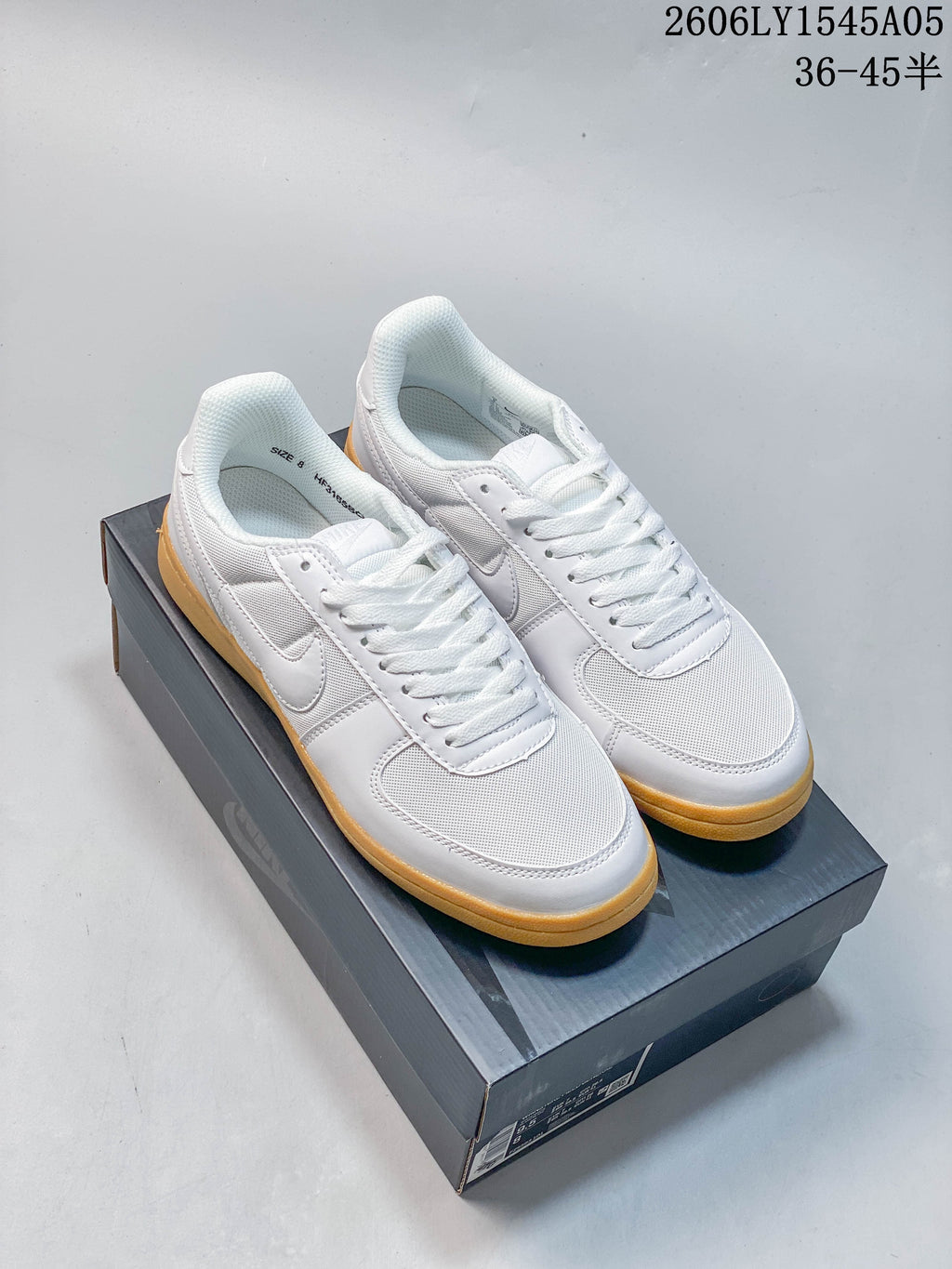 Pair of white Nike Field General low-top sneakers with gum-colored soles on a shoe box.