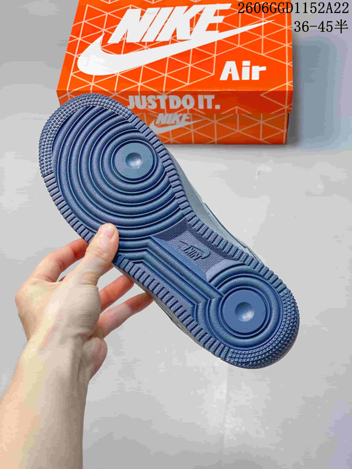 Underside of a Nike Air Force 1 sneaker showing a dark blue tread outsole