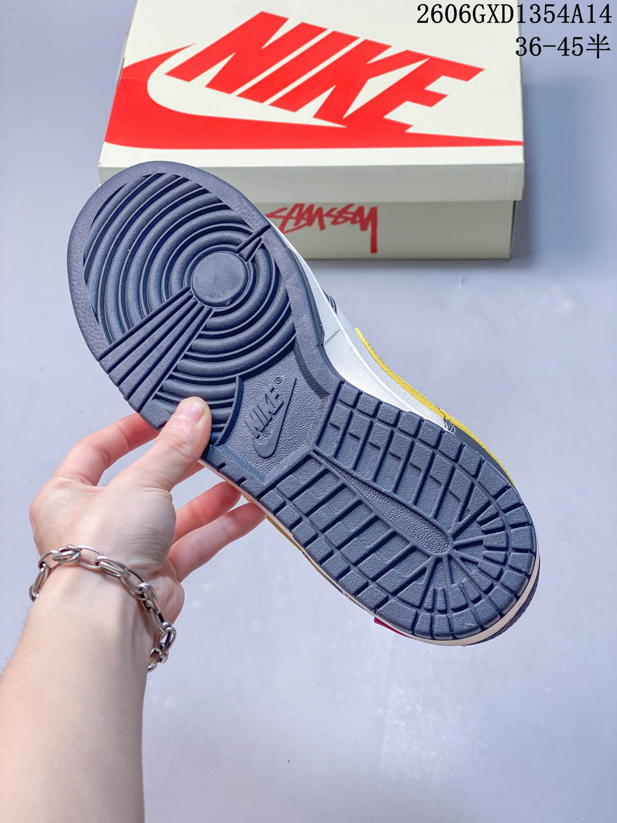 Close view of the dark outsole with circular and geometric tread, held in front of a shoebox.