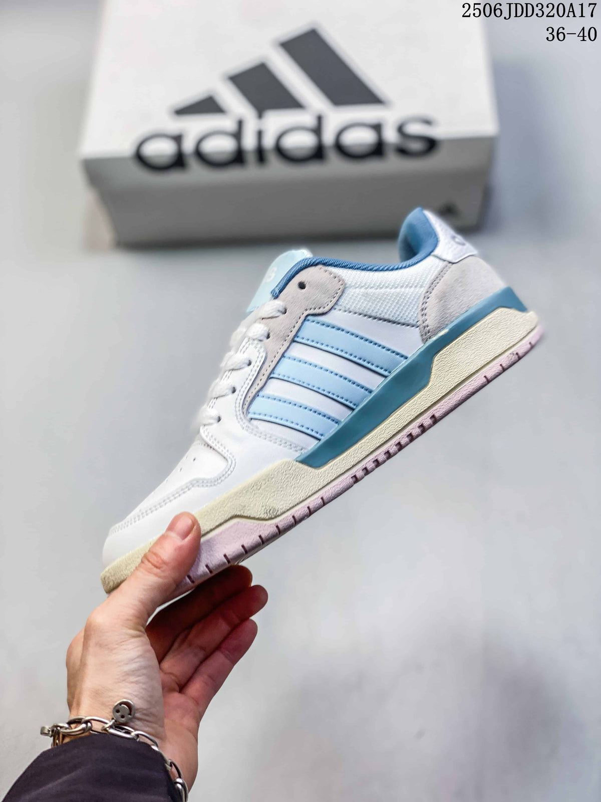 Side view of the white sneaker with light blue stripes and a contrasting outsole.
