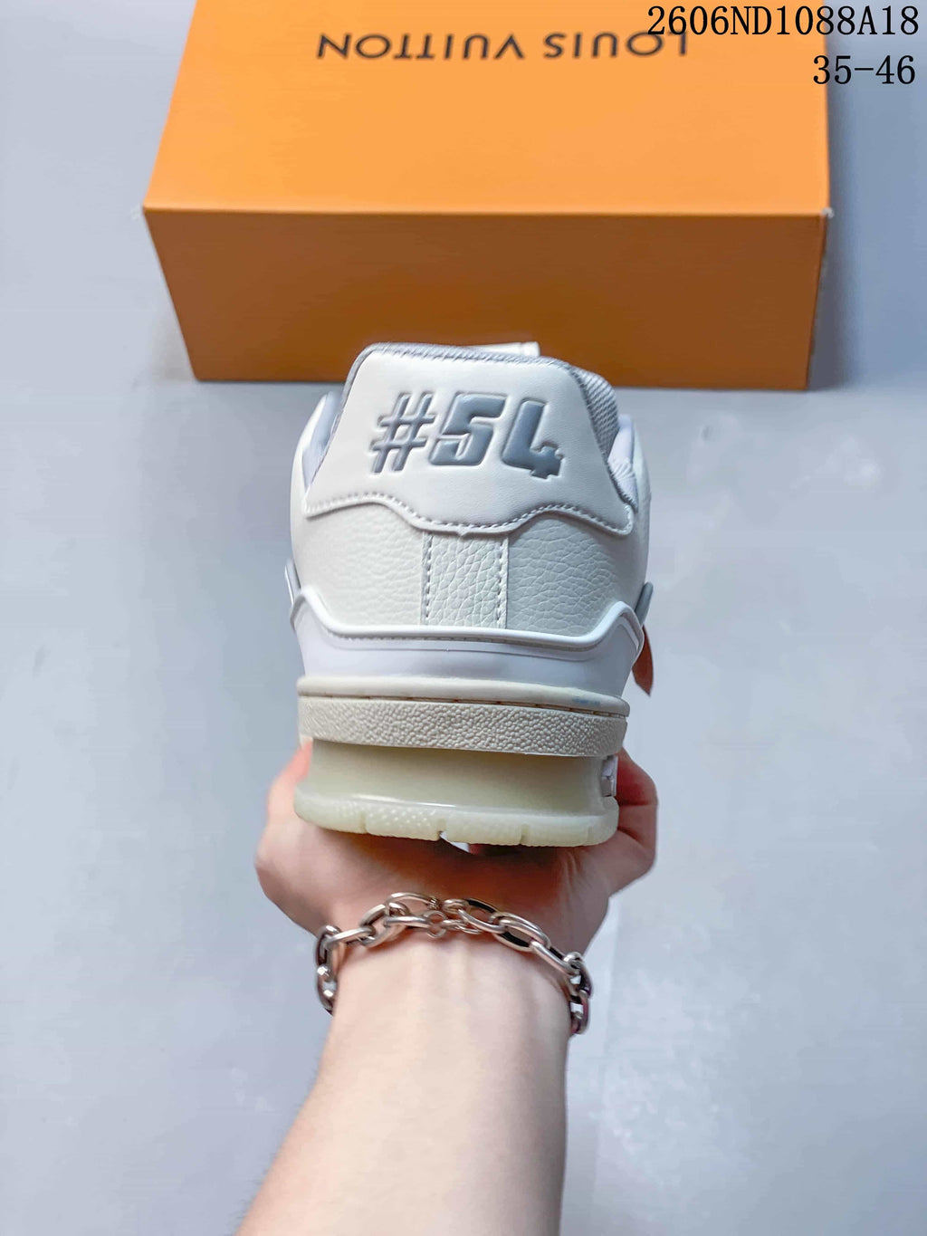 Rear view showing the heel detail and layered sole of a white Trainer sneaker