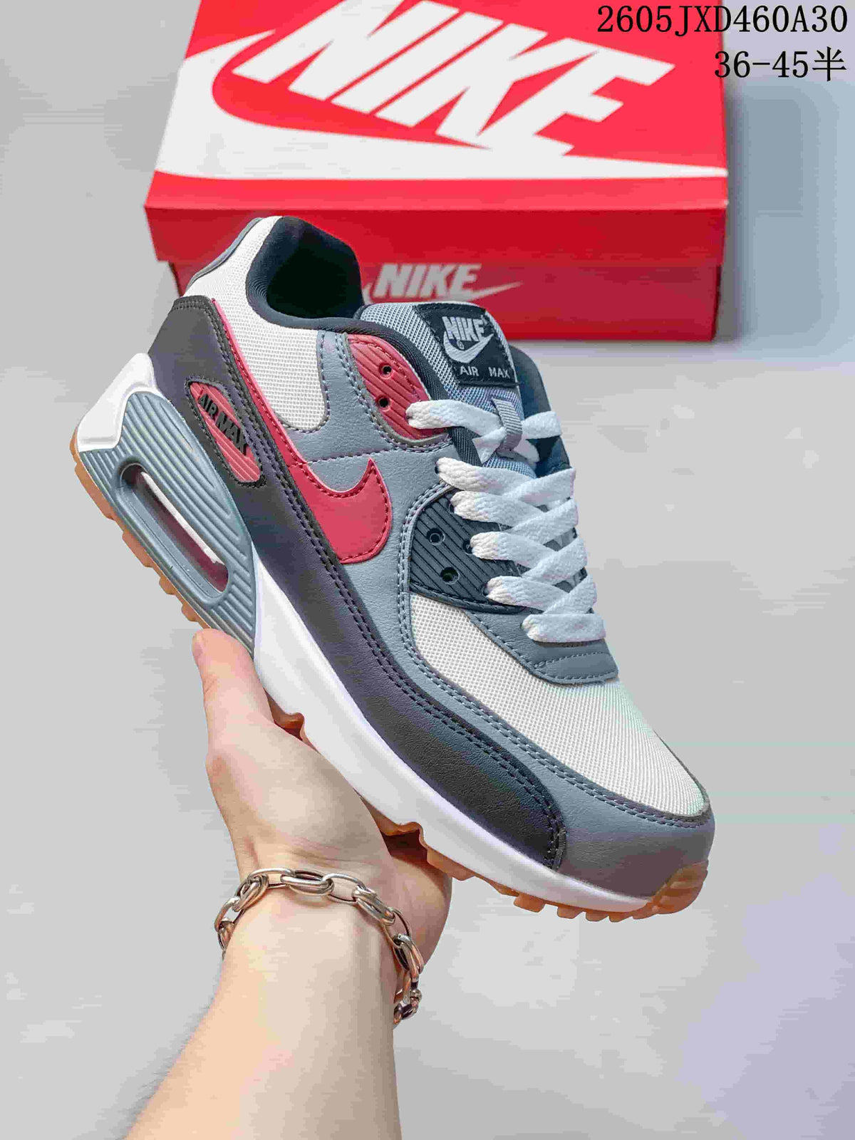 Angled close-up of the Nike Air Max 90 showing the side Swoosh, heel Air unit, and gum-colored outsole.