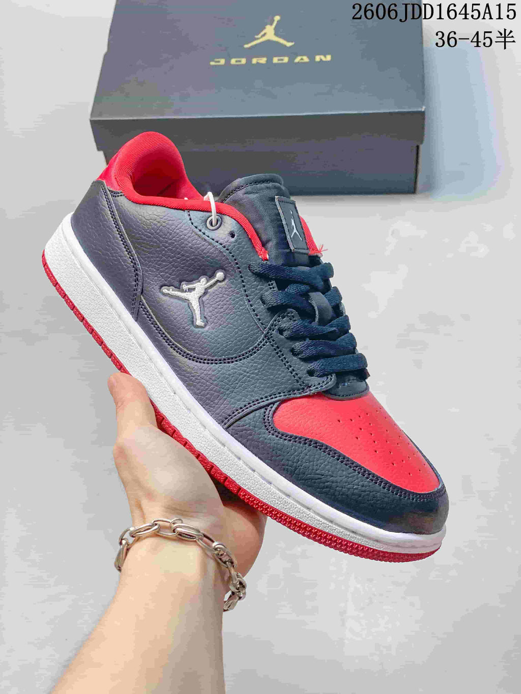 Side view of a dark gray Jordan Court Connect sneaker with red accents and a white midsole.