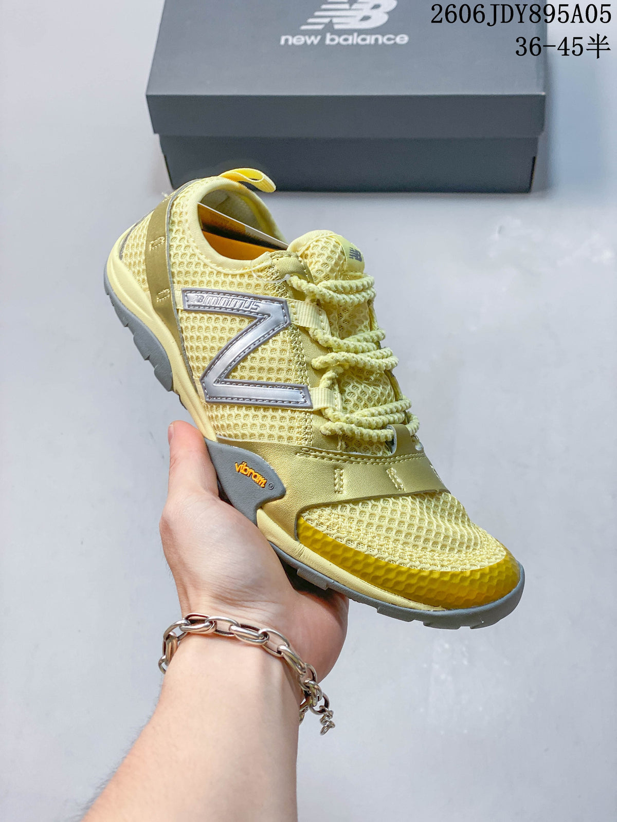 Angled side view of the yellow and gold-toned New Balance sneaker