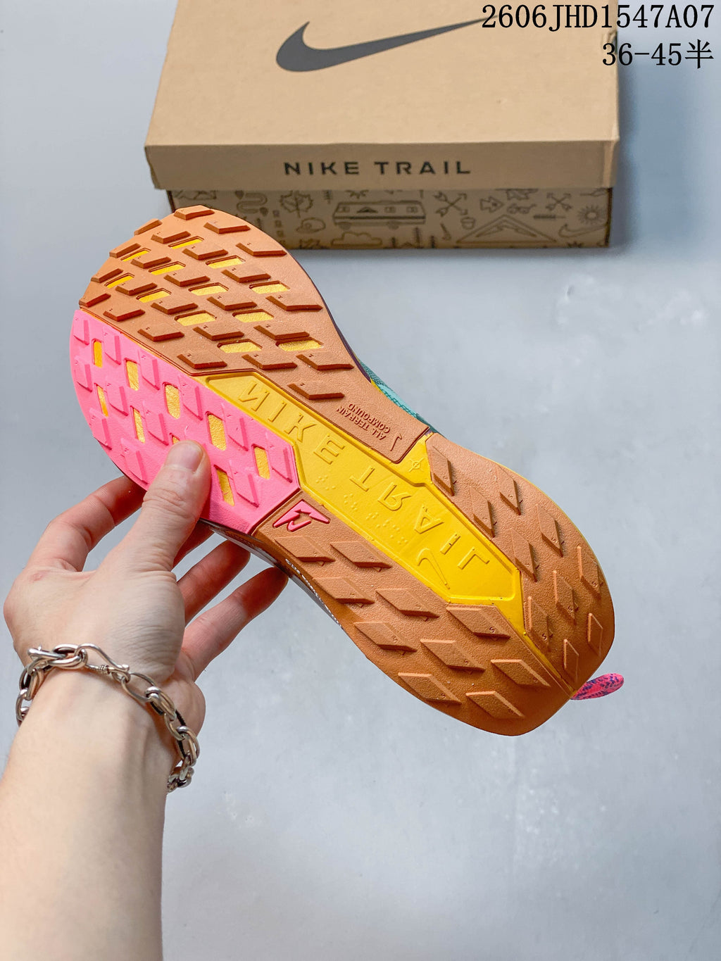 Close view of the Nike ReactX Pegasus Trail 5 outsole with multicolor trail lugs.