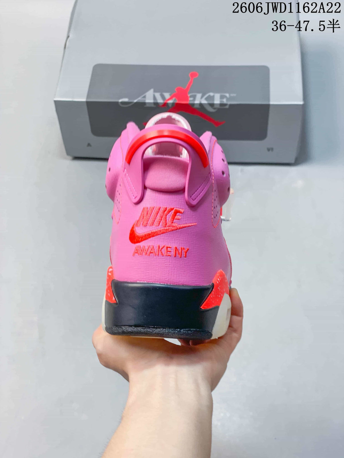 Rear view of the pink Air Jordan 6 with red-orange heel branding and pull tab