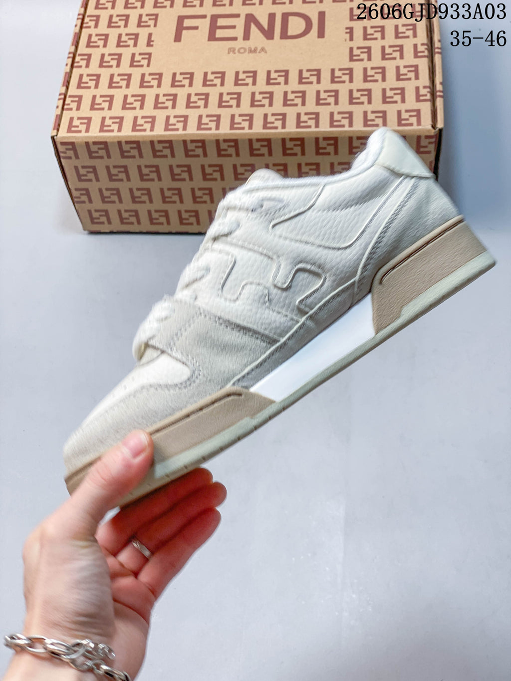 Side profile of a white low-top sneaker with layered panels and beige sole accents; image overlay shows 2606GJD933A03 and sizes 35–46.