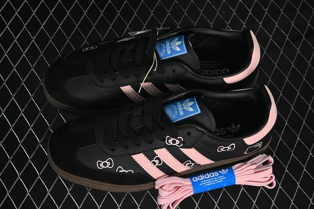 Pair of black and pink sneakers displayed with extra pink laces
