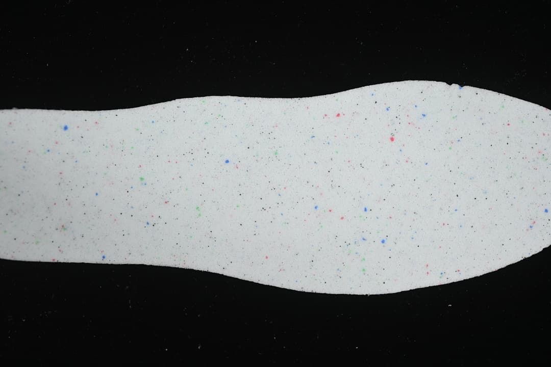 Light-colored sneaker insole with small colored speckles