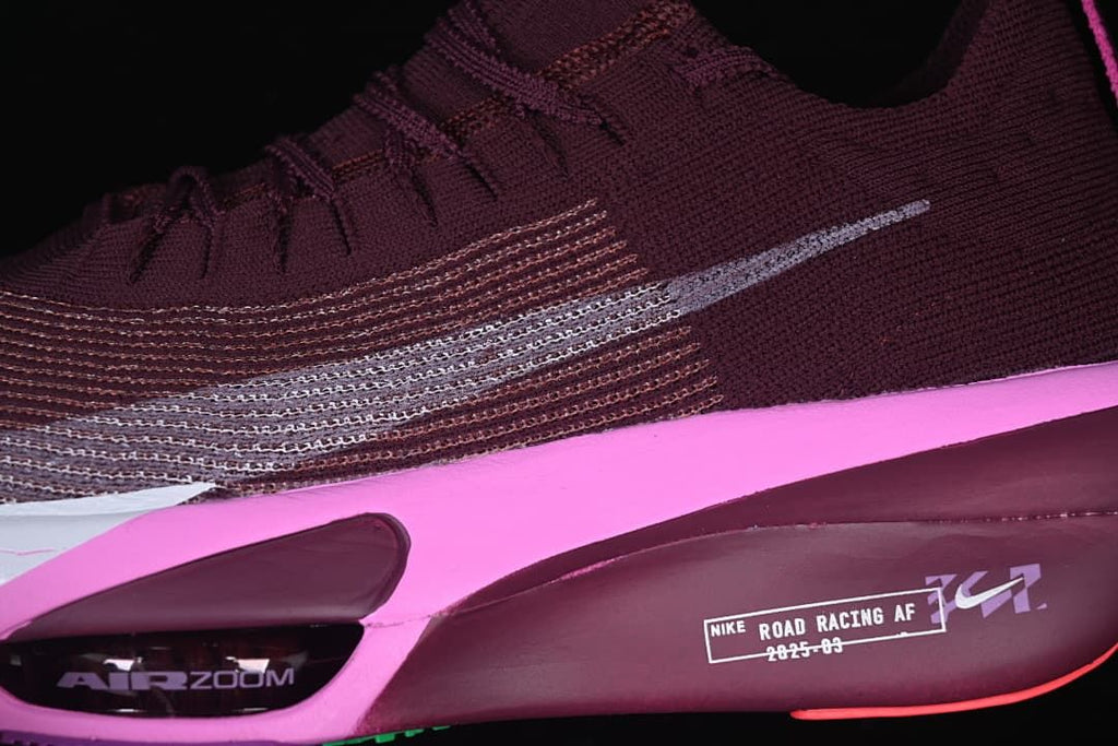Close-up of the side Swoosh, burgundy upper, and pink midsole accent