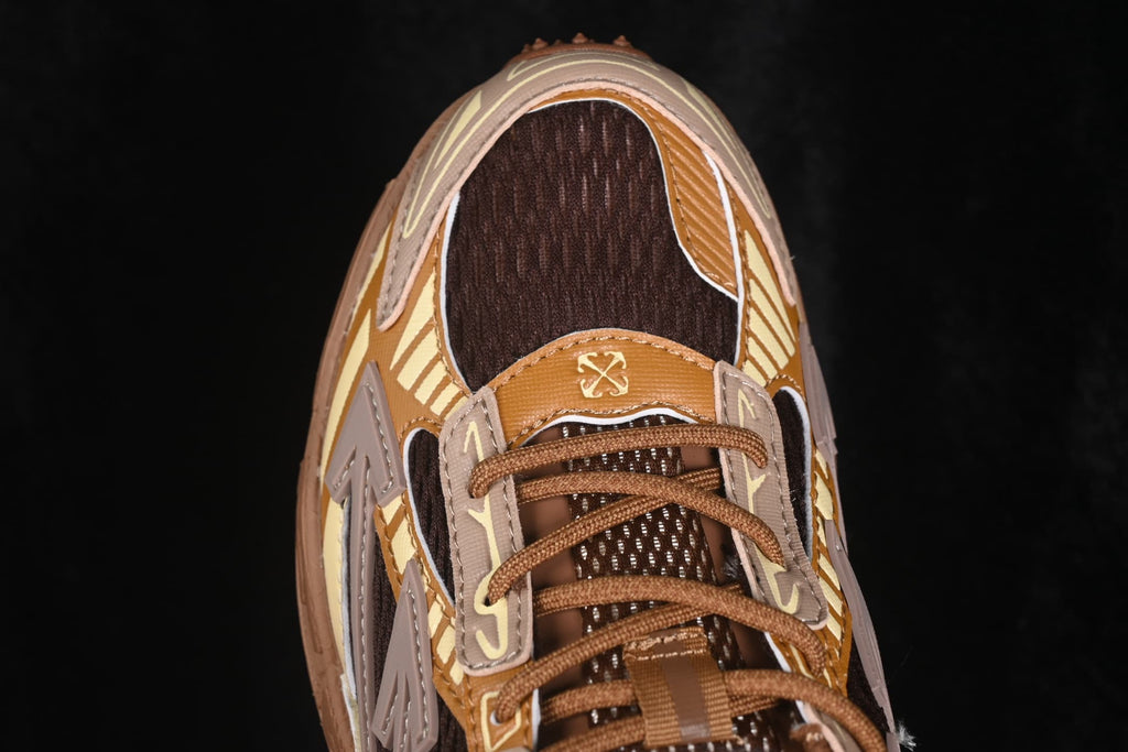 Close top view of the toe box, brown mesh, laces and contrast overlay panels.