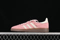 Side profile of pink and off-white adidas Handball Spezial sneakers with a gum outsole